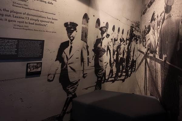 Darstellung des Lebens im Warschauer Ghetto mit Stacheldraht, gelben Armbinden und Davidstern – Symbol der Isolation und Verfolgung der jüdischen Bevölkerung während der NS-Zeit